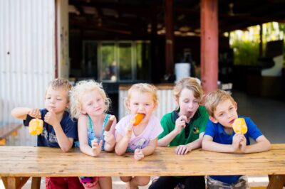 Kids eating mango icy poles and ice creams made by Crazy Acres 